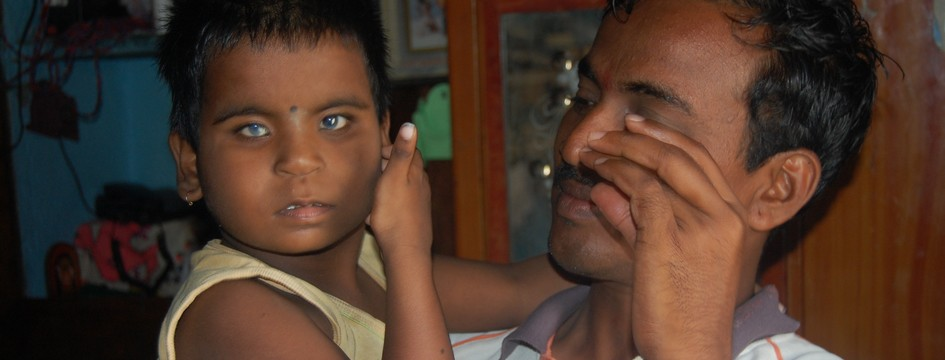 A caregiver gently holding a young visually challenged child.