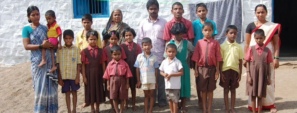 Students and staff of Jnanasindhu School standing together in front of the school building.
